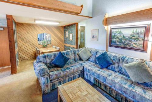 Una sala de estar con un sofá azul y una mesa. en Aspen Creek #401 Year-Round Outdoor Activities, en Mammoth Lakes
