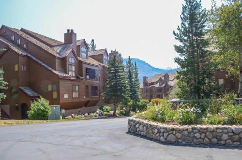 una casa grande con una pared de piedra frente a una calle en Aspen Creek #401 Year-Round Outdoor Activities, en Mammoth Lakes
