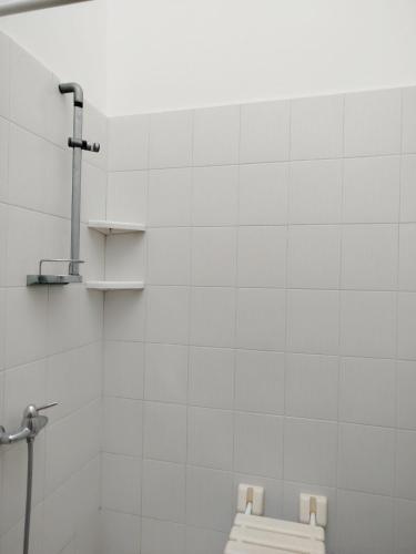 a white tiled bathroom with a bench in it at MarGaMik Holiday in Aradeo