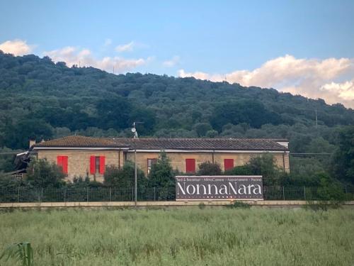 a building with a sign in front of a mountain at Nonna Nara Bed & Breakfast in Grosseto