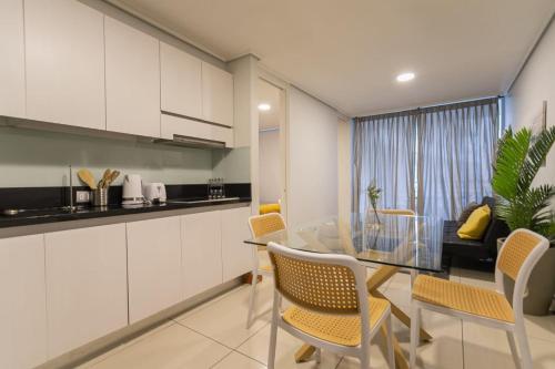 a kitchen and dining room with a glass table and chairs at Your Sophisticated Retreat in Las Condes in Santiago
