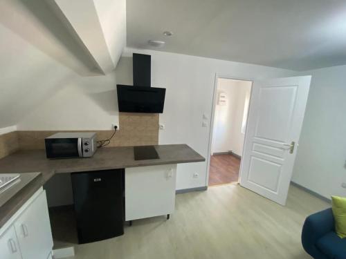 - une cuisine avec un comptoir et un four micro-ondes dans l'établissement Appartement Asskaf, à Cambrai