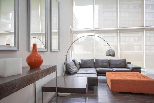 a living room with a couch and a table at Your Sophisticated Retreat in Las Condes in Santiago