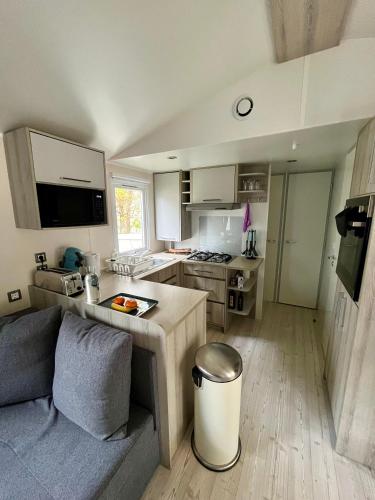 a kitchen with a couch and a table in a room at Joli Mobilhome 6P Camping Bois Dormant in Saint-Jean-de-Monts
