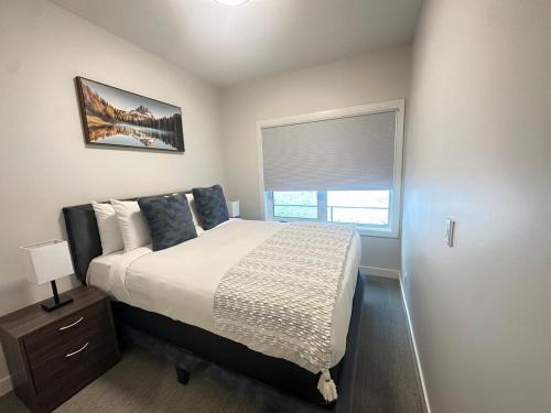 sypialnia z dużym łóżkiem i oknem w obiekcie Skyridge Resort -New Townhouse Near Banff Entrance w mieście Canmore