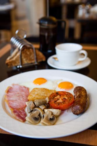 a plate of breakfast food with eggs mushrooms and bacon at The Claremont in Brighton & Hove