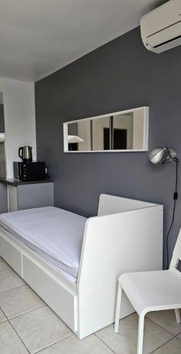 - une chambre avec un lit blanc et une chaise blanche dans l'établissement Studio meublé-Juan Pins-Logt3, à Antibes