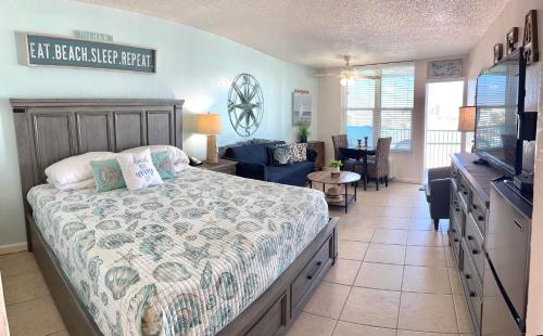 a bedroom with a bed and a living room at Beach Condo with Pool & Tiki Bar! in Daytona Beach