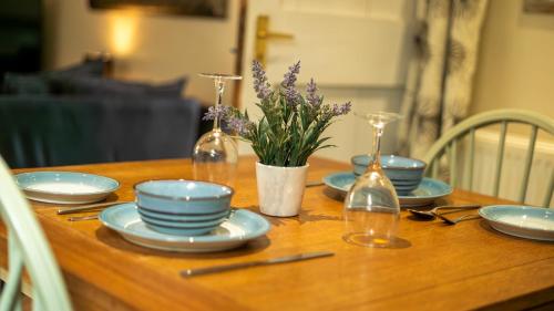 a wooden table with blue and white dishes and bottles at Willow cottage with private hot tub in Upper Hulme
