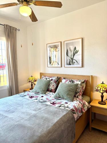 a bedroom with a bed with two lamps and a ceiling fan at Casa del Sol with private pool in Mazarrón