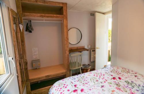 a bedroom with a bed and a mirror at Ramshaw View in Leek