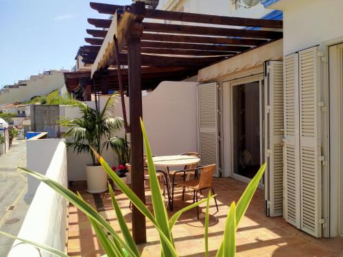 a patio with a table and chairs on a balcony at Apartment Rincón de Marinos in Almuñécar