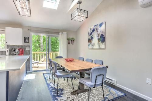 a kitchen and dining room with a wooden table and chairs at Creek Front Pocono Mountain Getaway with Game room & Sauna in Tobyhanna