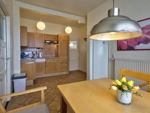 a kitchen with a table with a vase of flowers on it at Ferienwohnung am Strand F991 in Fehmarn