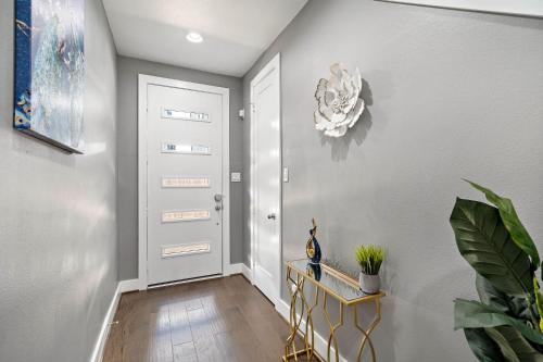 a hallway with a white door and a plant at Luxury Downtown Home with Rooftop Deck And Skyline View in Angleton