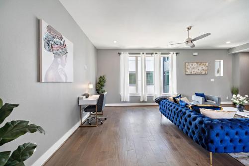 a living room with a blue couch and a desk at Luxury Downtown Home with Rooftop Deck And Skyline View in Angleton