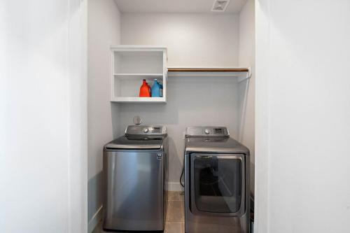 a small kitchen with a stove and a microwave at Luxury Downtown Home with Rooftop Deck And Skyline View in Angleton