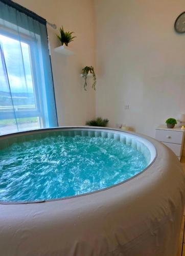 a large hot tub in a room with a window at Ballycrystal House Getaway in Bunclody