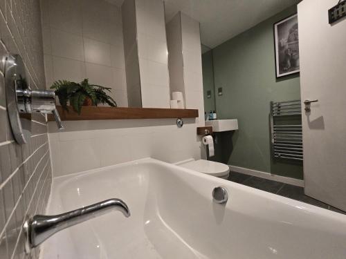 een badkamer met een wit bad en een toilet bij Ventro Apartments LIVERPOOL in Liverpool