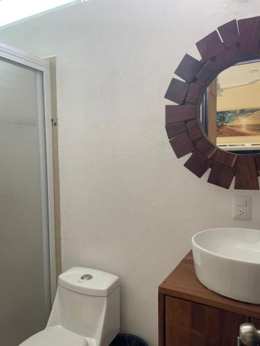 a bathroom with a white toilet and a mirror at Casa Arizona in Brisas de Zicatela