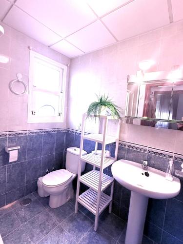 a bathroom with a toilet and a sink and a shelf at Casa del Sol with private pool in Mazarrón