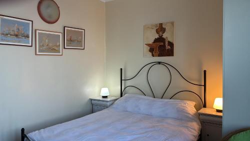 a bedroom with a bed and some pictures on the wall at ElStefanino House in Eforie Nord