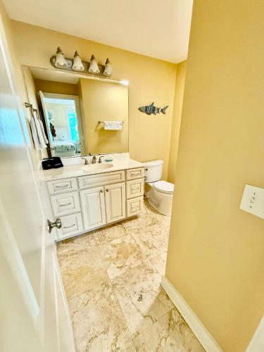 a bathroom with a sink and a toilet and a mirror at Tybee Retreat Unit 1 in Tybee Island