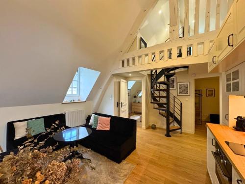 - un salon avec un canapé noir et un escalier en colimaçon dans l'établissement La Petite Orangerie - near castle, à Rambouillet