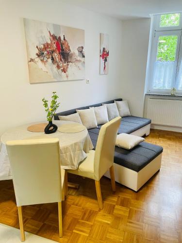 a living room with a couch and a table and chairs at Topel dom v centru mesta 5 in Maribor