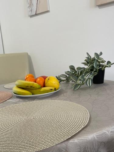 a plate of bananas oranges and other fruits on a table at Topel dom v centru mesta 5 in Maribor