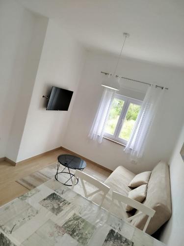 a white living room with a couch and a table at Brine in Starigrad-Paklenica