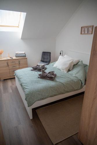 a bedroom with a bed with shoes on it at Pipi és Papi vendégház in Kiskunlacháza