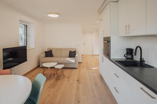 a kitchen and living room with a couch and a table at Apart Suites Gravbach in Lagundo