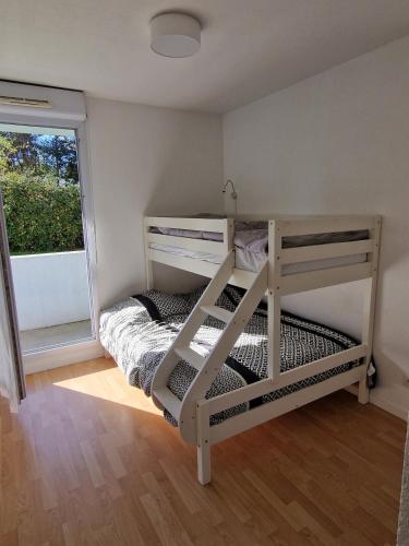 una piccola camera da letto con un letto a castello e una finestra di Superbe appartement en residence avec piscine a La Rivière Saint Sauveur