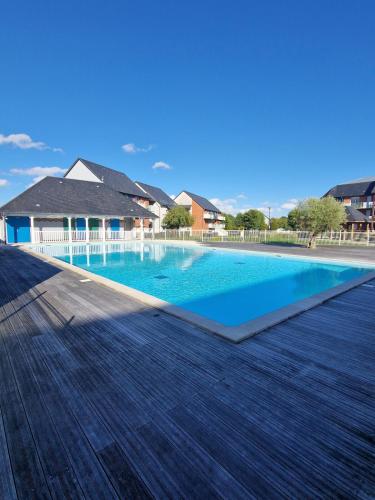 une grande piscine sur une terrasse en bois dans l'établissement Superbe appartement en residence avec piscine, à La Rivière-Saint-Sauveur