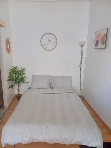 a bedroom with a bed with a clock on the wall at Le minimaliste in Pamiers