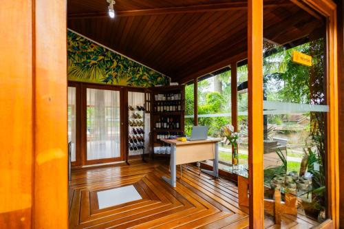 an office with a desk in a room with windows at Putini Pousada e Hotel by OYO in São Roque
