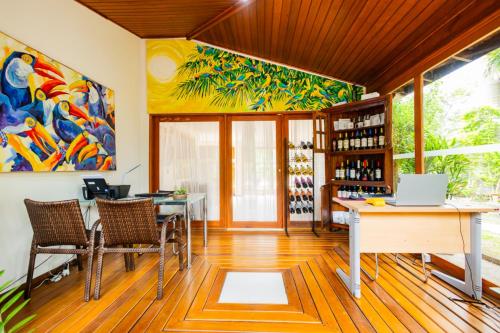 an office with a desk and chairs and a painting at Putini Pousada e Hotel by OYO in São Roque