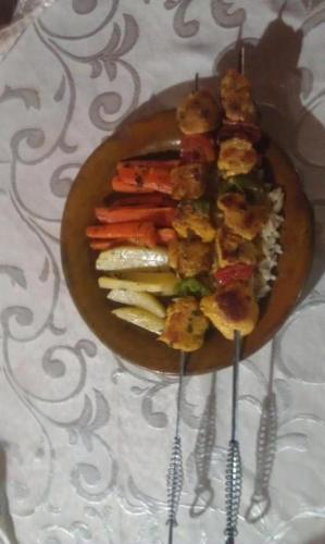 a plate of food on a table with two forks at Alliance tradition in Boumalne