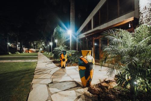 two vases on a sidewalk in front of a building at Putini Pousada e Hotel by OYO in São Roque