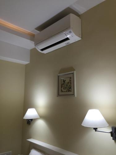 two lights on the wall of a room with two lamps at Daffodils Spice Court in Cochin