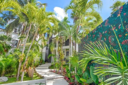 a building with palm trees in front of it at Breeze House - Paradise awaits in Akumal