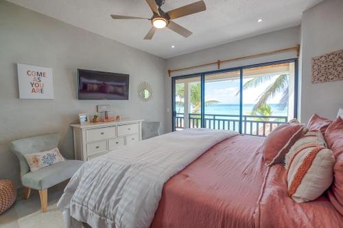 a bedroom with a bed and a television and a window at Breeze House - Paradise awaits in Akumal