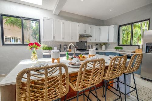 a kitchen with white cabinets and a table with chairs at Breeze House - Paradise awaits in Akumal