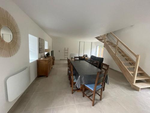 a dining room with a table and a staircase at Gîte de penhaudan 1 in Pont-Scorff