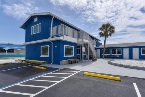 a blue building with a parking lot in front of it at Modern King Suite #12 - Steps to Beach in Daytona Beach