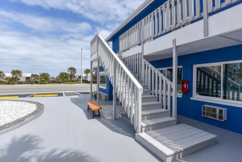 a blue building with stairs and a bench next to it at Modern King Suite #12 - Steps to Beach in Daytona Beach