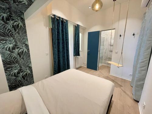 une chambre avec un lit blanc et des rideaux bleus dans l'établissement Suite moderne à Draguignan - Élégance Urbaine, à Draguignan