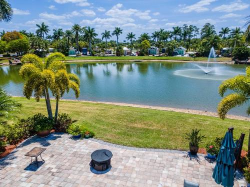 Riverbend Motorcoach Resort Lot 93 في La Belle: بركة مع نافورة وأشجار نخيل في حديقة