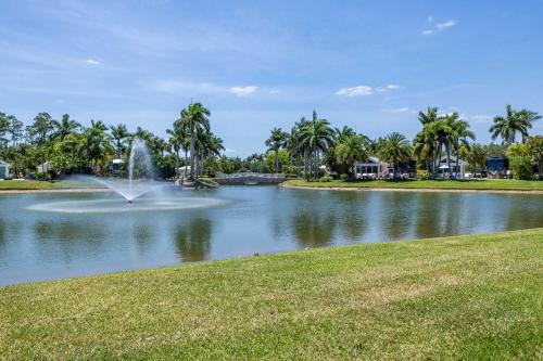 Riverbend Motorcoach Resort Lot 93 في La Belle: بركة فيها نافورة وسط حديقة